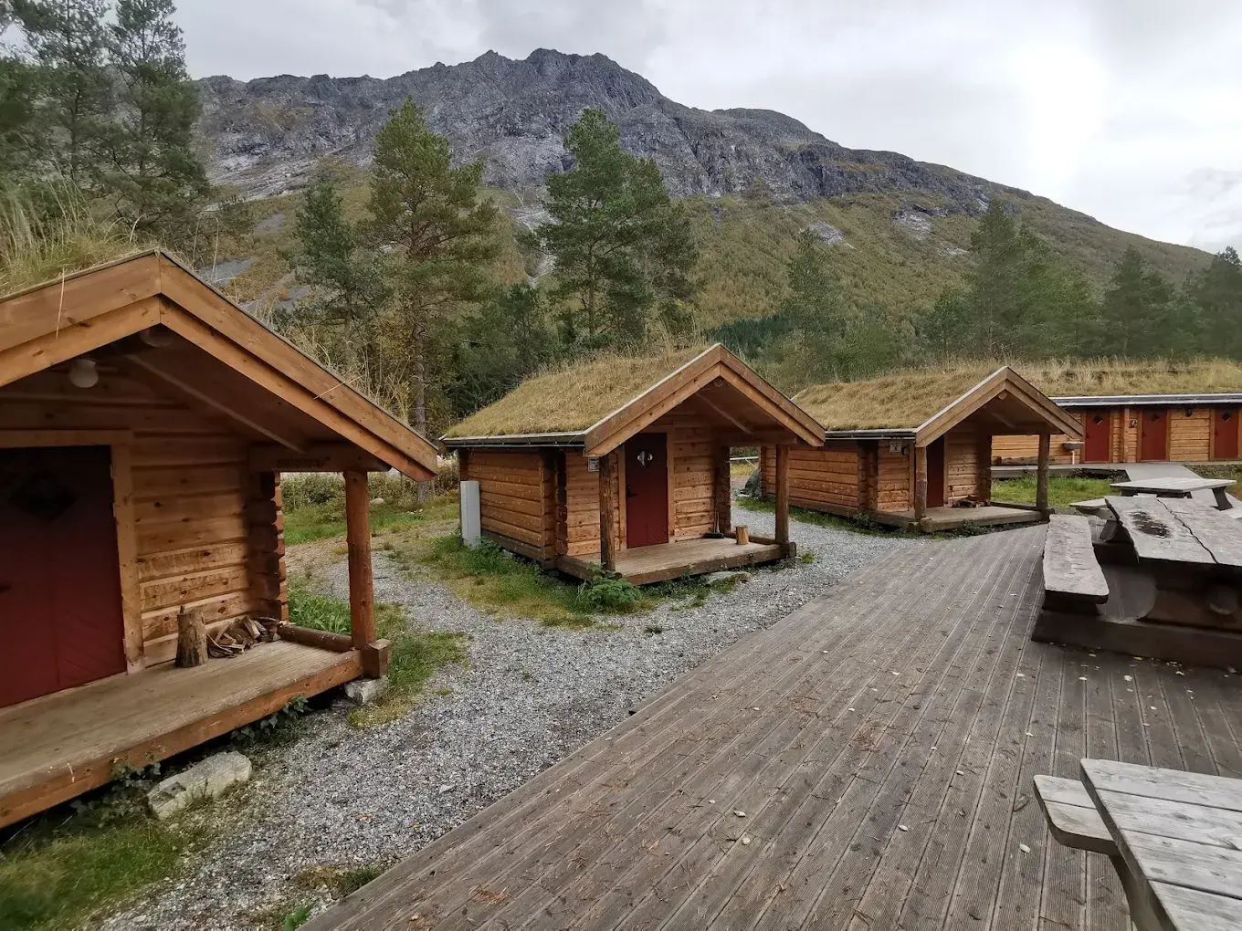 Tømmerhytter med fjell i bakgrunnen
