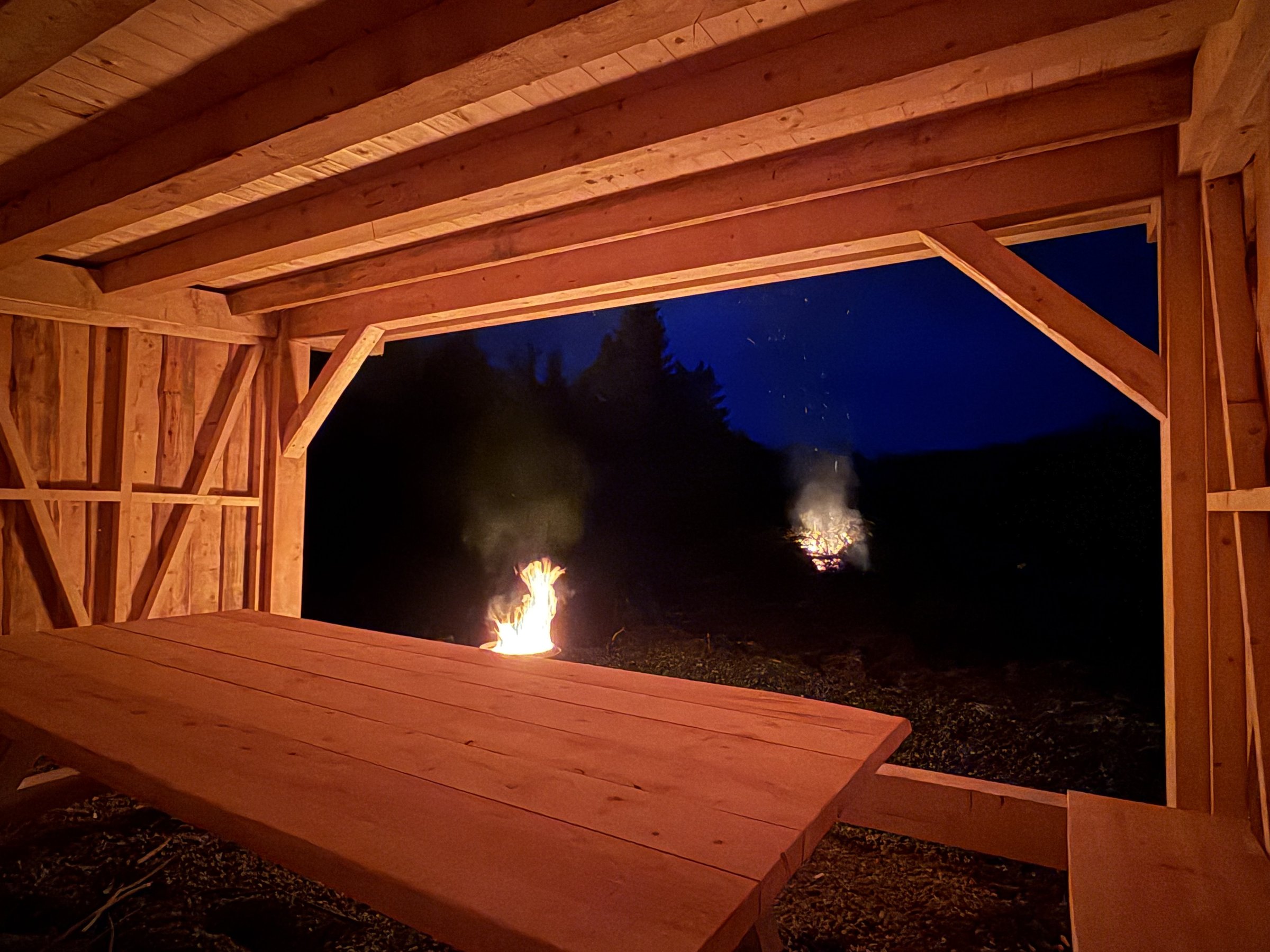Utsikt fra gapahuken med bål i kveldslys