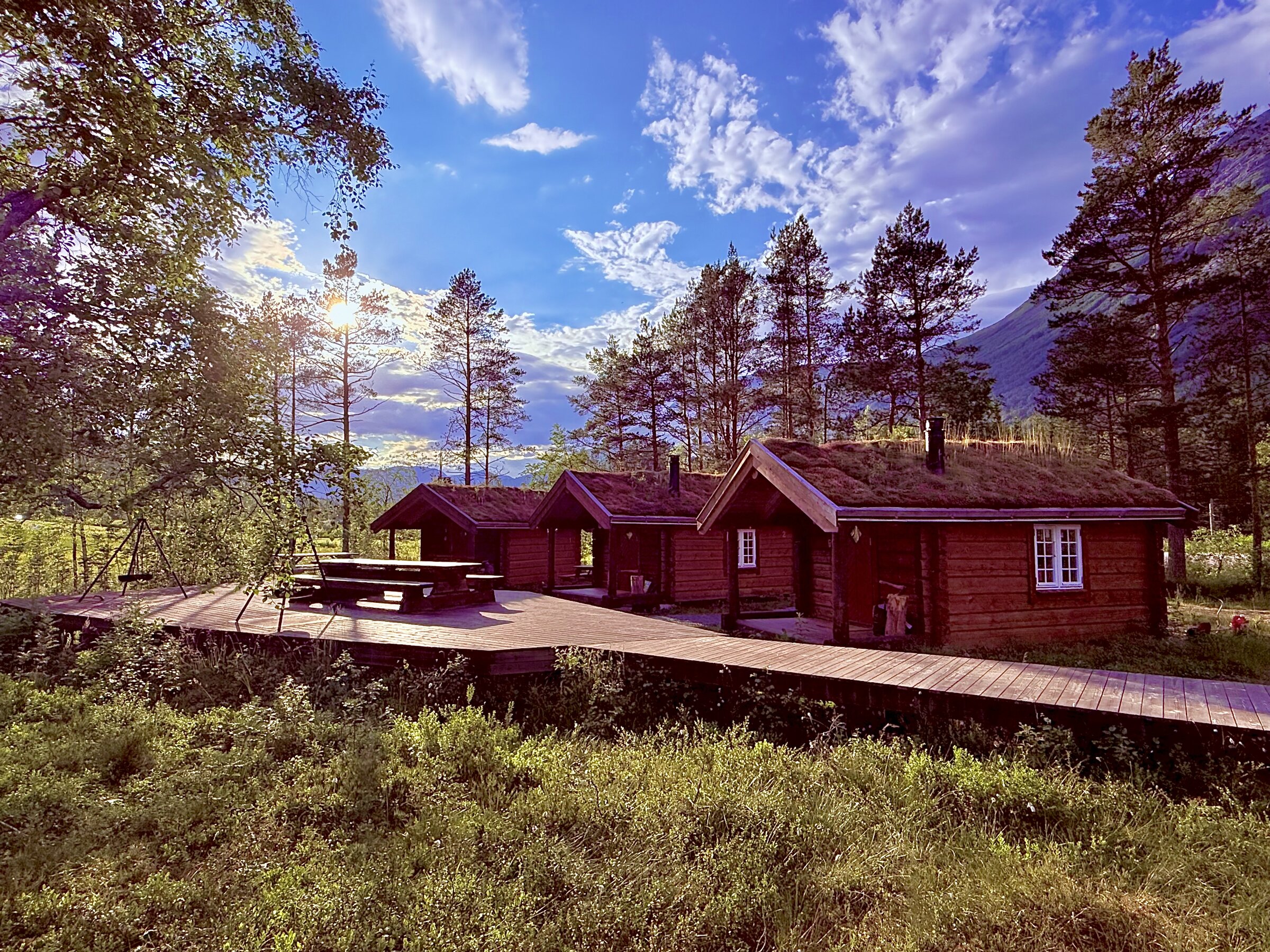 Tømmerhyttene med fjell i bakgrunnen
